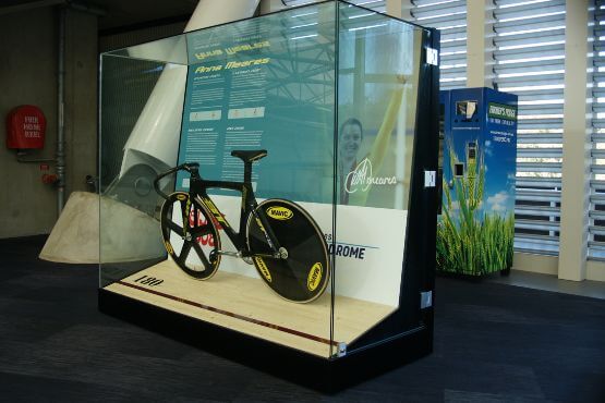 glass showcase with mounted olympic bike and graphic panel behind anna meares velodrome
